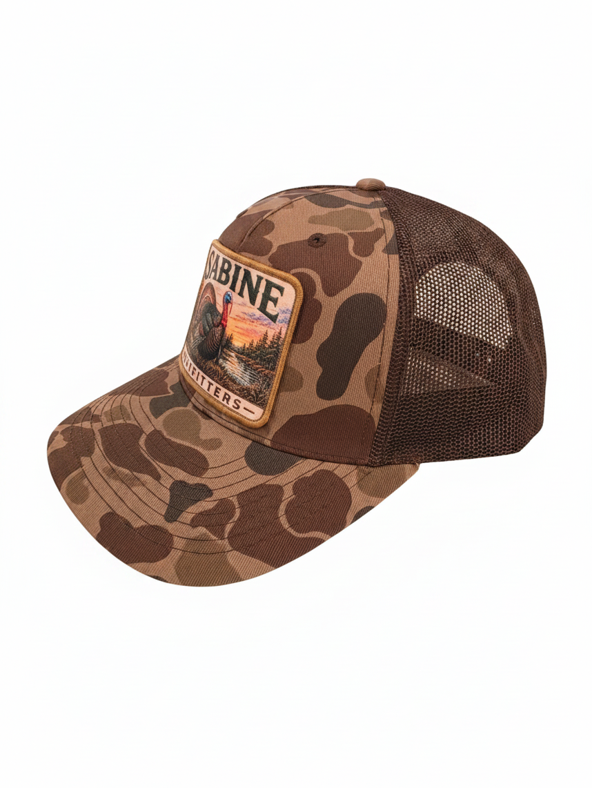 Sabine Outfitters trucker hat with camo front, brown mesh back, and a turkey patch on a white background.